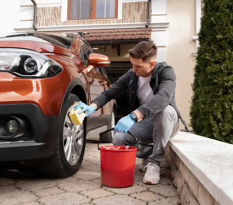 Lavage auto à domicile Condé-sur-l'Escaut : professionnel intervenant sur un véhicule